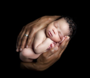 newborn baby in hands, African American hands, colors, young baby, shoot